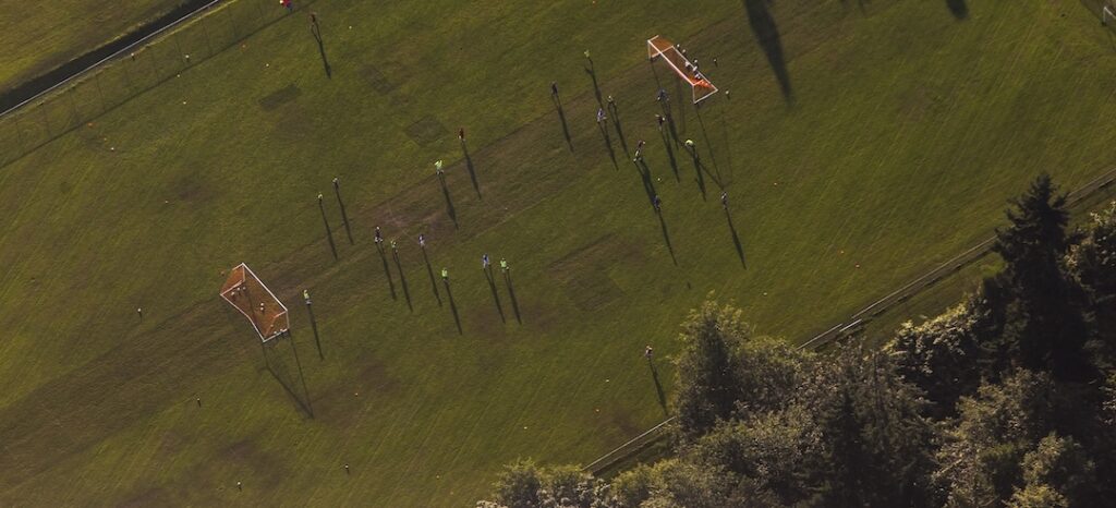 An overhead view of a green soccer field in action.