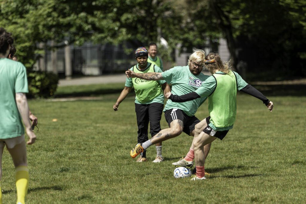 Soccer players make contact with a ball at their feet.